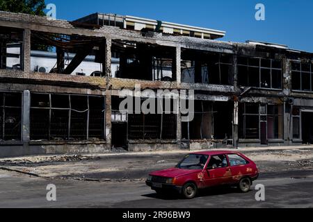 Cherson, Ukraine. 24. Juni 2023. Auto fährt vor dem zerstörten Gebäude in Kherson, Ukraine, 24. Juni 2023. Kredit: Ondrej Deml/CTK Photo/Alamy Live News Stockfoto
