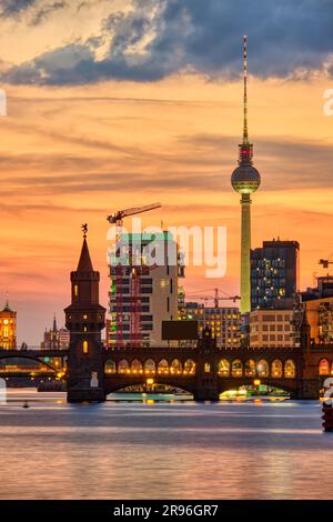 Dramatischer Sonnenuntergang an der Oberbaumbrücke und dem berühmten Fernsehturm in Berlin Stockfoto