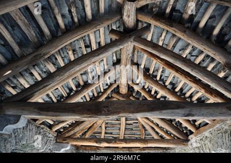 Alte urige Hütte mit Stein Dach und Holzbalken von drinnen in der Schweiz Stockfoto