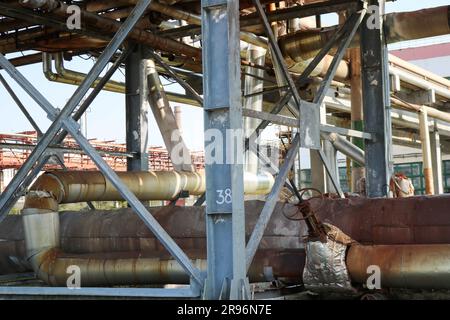 Rohrleitung Östocada, Rohre mit Dampf und Kondensat, mit einem großen Ventilator mit blauen Balken in einer Ölraffinerie, Petrochemie, Chemie. Stockfoto