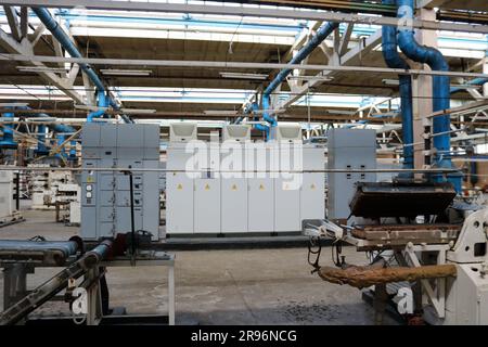 Wunderschöne industrielle Metallanlagen einer Produktionslinie in einem Maschinenbauwerk, ein Förderband mit Werkzeugmaschinen für Produkte. Maschinenraffinerie, Stockfoto