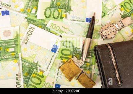 Goldener Feuerzeugwecker auf dem Hintergrund von grünem Geld 100-Euro-Scheine Stockfoto