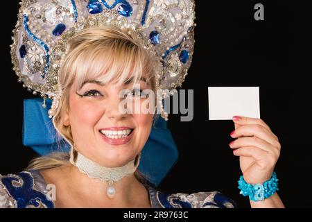 Lächelndes Mädchen im traditionellen russischen weihnachtskostüm von Snegurochka Snow Maiden mit leerem Banner, isoliert auf schwarzem Hintergrund Stockfoto