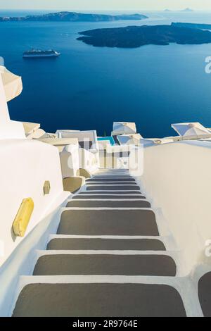 Treppe nach unten, Segeltörn und Vulkaninsel Nea Kameni in Caldera. Foto gemacht in Firostefani, Santorin, Griechenland, ein einzigartiger, fantastischer Ort Stockfoto