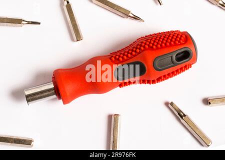 Roter Schraubendreher, weißer Hintergrund und Bits, Ersatzteile Stockfoto