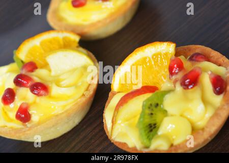 Cremes Torte mit farbigen Früchten in einem Korb Stockfoto