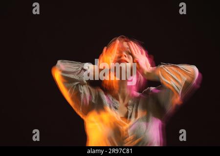 Junge Frau tanzt zeitgenössisch auf schwarzem Hintergrund, Bewegungsunschärfe-Effekt Stockfoto