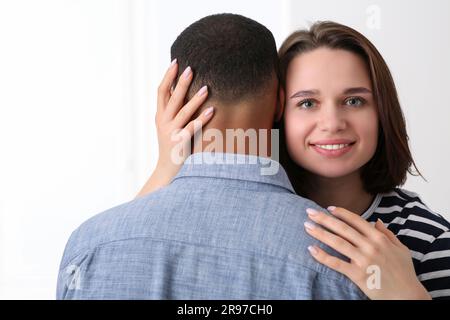 Dating-Agentur. Eine Frau, die ihren Freund auf weißem Hintergrund umarmt Stockfoto