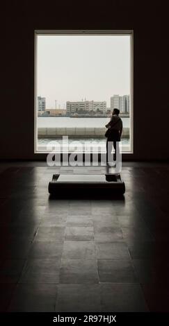 Ein Mann blickt durch das Fenster auf das Louvre Museum, Abu Dhabi, VAE Stockfoto