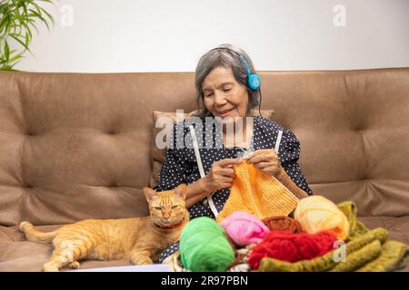 Musik- und Stricktherapie bei Demenzbehandlung bei älteren Frauen. Stockfoto