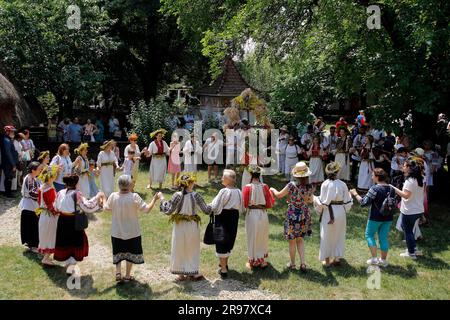 Bukarest, Rumänien. 24. Juni 2023. Besucher tanzen mit jungen, als Feen verkleideten Mädchen während des traditionellen Volksfestivals „Sanziene“ in Bukarest, der Hauptstadt Rumäniens, am 24. Juni 2023. Alte Traditionen erwähnen „Sanzienele“ als sanfte Feen, die um die Sommersonnenwende kommen, um Glück und gute Ernte zu bringen. Kredit: Cristian Cristel/Xinhua/Alamy Live News Stockfoto