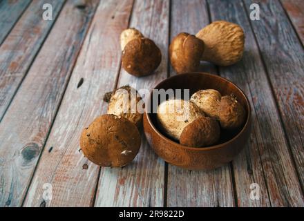 Pilz-Boletus auf Holzhintergrund. Pilze in Holzschüssel Stockfoto