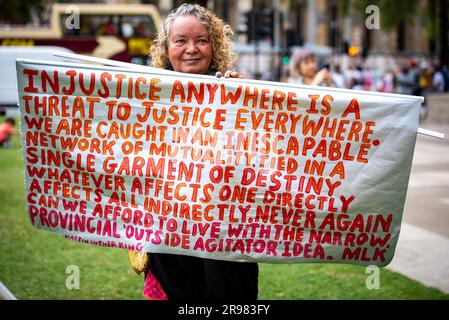 Ein Demonstrant hält ein großes Banner während der "Was zu sagen?" Freier Julian Assange-Protest am Parliament Square in London. „Haben Sie Etwas Zu Sagen?“ Ist eine lebensgroße Bronzeskulptur, in der jeweils drei Figuren dargestellt werden, die auf einem Stuhl des Künstlers Davide Dormino stehen. Der vierte Stuhl ist leer, weil er unser Stuhl ist. Der, auf dem wir uns erheben, um uns auszudrücken oder einfach nur neben Edward Snowden, Julian Assange und Chelsea Manning zu stehen, die den Mut hatten, Nein zu der Einmischung in die globale Überwachung und zu Lügen zu sagen, die zu Krieg führten. (Foto: Loredana Sangiuliano/SOPA Images/Sipa USA) Stockfoto