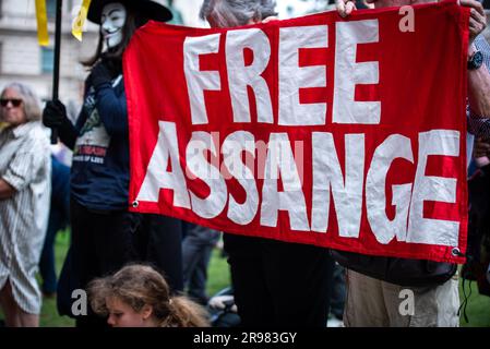 Ein Demonstrant hält ein großes Banner während der "Was zu sagen?" Freier Julian Assange-Protest am Parliament Square in London. „Haben Sie Etwas Zu Sagen?“ Ist eine lebensgroße Bronzeskulptur, in der jeweils drei Figuren dargestellt werden, die auf einem Stuhl des Künstlers Davide Dormino stehen. Der vierte Stuhl ist leer, weil er unser Stuhl ist. Der, auf dem wir uns erheben, um uns auszudrücken oder einfach nur neben Edward Snowden, Julian Assange und Chelsea Manning zu stehen, die den Mut hatten, Nein zu der Einmischung in die globale Überwachung und zu Lügen zu sagen, die zu Krieg führten. (Foto: Loredana Sangiuliano/SOPA Images/Sipa USA) Stockfoto