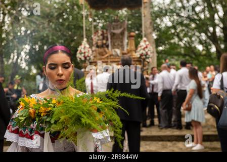 Eine junge Frau mit einem Blumenstrauß bei religiösen Prozessionen in Popayan auf Domingo de Ramos, dem ersten Tag von Semana Santa Stockfoto