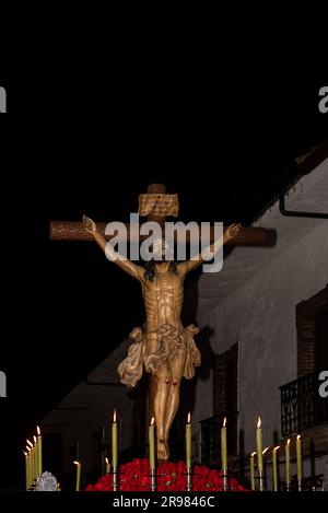 Eine Statue Jesu Christi hängt nachts am Kreuz mit brennenden Kerzen bei den religiösen Prozessionen in Popayan Stockfoto