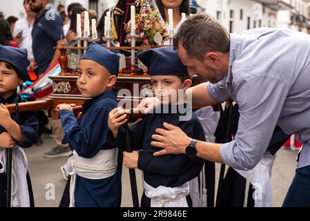 Ein Mann umarmt einen kleinen Jungen bei religiösen Prozessionen in Popayan auf Domingo de Ramos Stockfoto