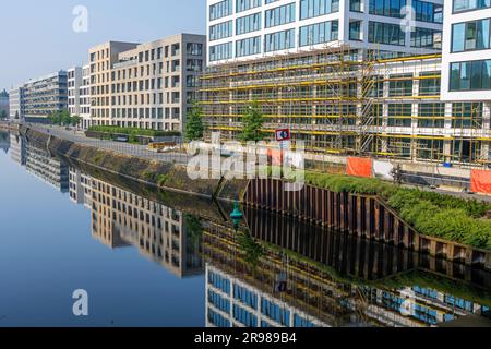 Neue Appartementhäuser mit Reflexionen in einem kleinen Kanal in Berlin Stockfoto