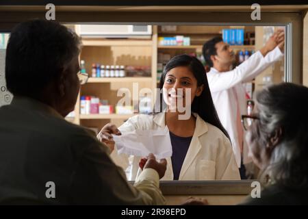 Chemiker Mann in der Apotheke - Drogeriemarkt. Nahaufnahme des Apothekers in der Krankenhausapotheke. Unterstützung für Kunden, Senior Old man Kunde am Schalter. Stockfoto