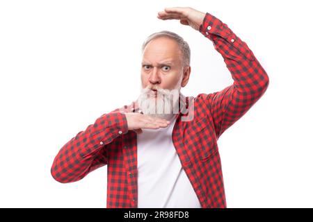 Hübscher 60s-jähriger Rentner mit weißem Bart und Schnurrbart, der ein Gesicht macht Stockfoto