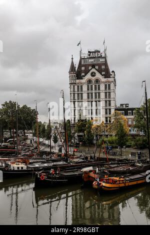 Rotterdam, NL - 6. Oktober 2021: Boote im alten Hafen von Rotterdam, Oude Haven, und das Weiße Haus, Witte Huis Gebäude im Hintergrund bei Regen Stockfoto