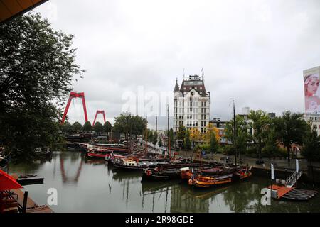 Rotterdam, NL - 6. Oktober 2021: Boote im alten Hafen von Rotterdam, Oude Haven, und das Weiße Haus, Witte Huis Gebäude im Hintergrund bei Regen Stockfoto