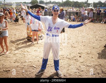 Elton John-Fan Thomas Lewis, 22 Jahre alt, aus Basingstoke, beobachtet das Bristol Reggae Orchestra - mit dem Windrush Chor - auf der Pyramide beim Glastonbury Festival auf der Worthy Farm in Somerset. Foto: Sonntag, 25. Juni 2023. Stockfoto