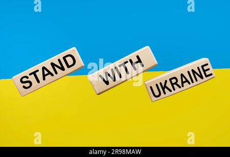 Holzblöcke mit dem Text stehen für Ukraine auf dem Tisch in der Farbe der ukrainischen Flagge Stockfoto