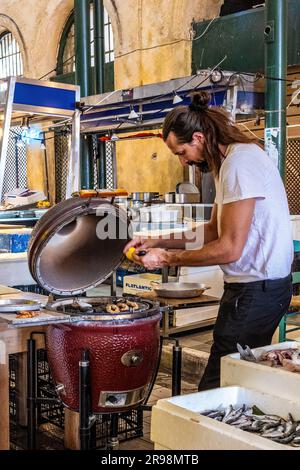 Fischstand für Streetfood auf dem zentralen Markt von Athen, Griechenland. Kochen Sie frischen Fisch für den Holzkohlegrill. Ausklappbares Streetfood. Stockfoto