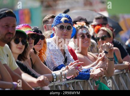 Elton John-Fan Thomas Lewis (Zentrum), 22 Jahre alt, aus Basingstoke, beobachtet das Bristol Reggae Orchestra - mit dem Windrush Chor - auf der Pyramide des Glastonbury Festivals auf der Worthy Farm in Somerset. Foto: Sonntag, 25. Juni 2023. Stockfoto