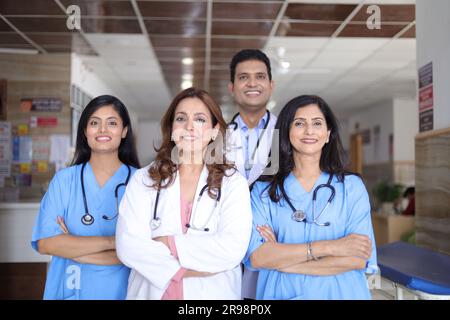 Porträt des glücklichen indischen medizinischen Teams, das im Krankenhauskorridor steht. Portrait eines multikulturellen Medical Team Standing together. Stockfoto