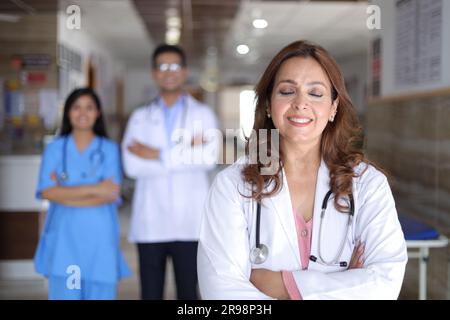 Porträt des glücklichen indischen medizinischen Teams, das im Krankenhauskorridor steht. Portrait eines multikulturellen Medical Team Standing together. Stockfoto