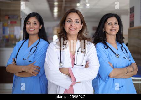 Porträt des glücklichen indischen medizinischen Teams, das im Krankenhauskorridor steht. Portrait eines multikulturellen Medical Team Standing together. Stockfoto