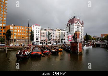 Rotterdam, NL - 6. Oktober 2021: Boote im alten Hafen von Rotterdam, Oude Haven, und das Weiße Haus, Witte Huis Gebäude im Hintergrund bei Regen Stockfoto