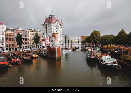 Rotterdam, NL - 6. Oktober 2021: Boote im alten Hafen von Rotterdam, Oude Haven, und das Weiße Haus, Witte Huis Gebäude im Hintergrund bei Regen Stockfoto