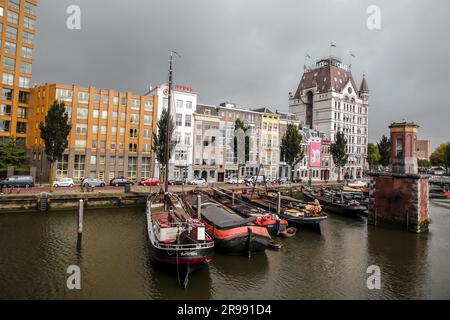 Rotterdam, NL - 6. Oktober 2021: Boote im alten Hafen von Rotterdam, Oude Haven, und das Weiße Haus, Witte Huis Gebäude im Hintergrund bei Regen Stockfoto