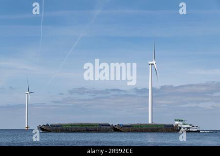 Schiebe-/Abschleppeinheit passiert einen Offshore-Windpark Stockfoto