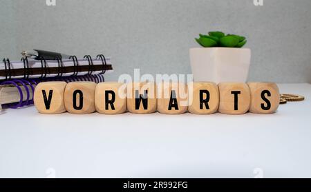 Buchstabenkombination mit Wort vorwärts in rotem Regal auf Holzhintergrund Stockfoto
