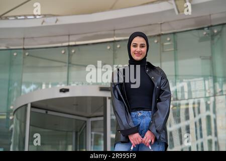 Junge muslimische Frau mit Hijab, die in die Kamera schaut Stockfoto