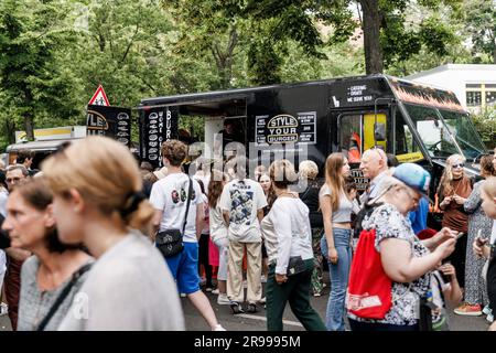 Berlin, Deutschland. 25. Juni 2023. Die Leute passieren Stände beim Straßenfestival, bei der Eröffnungszeremonie des Birnen Jüdischen Campus (PJC). Die größte jüdische Institution für Bildung, Kultur und Sport seit der Shoah hat in Berlin mit einem Straßenfestival eröffnet. Der Birnen Jüdische Campus in Wilmersdorf bietet 8.000 Quadratmeter Tagesbetreuung, Grund- und Oberschule, Kunst- und Musikstudios, ein Kino mit 100 Sitzplätzen sowie eine Sport- und Veranstaltungshalle. Kredit: Carsten Koall/dpa/Alamy Live News Stockfoto