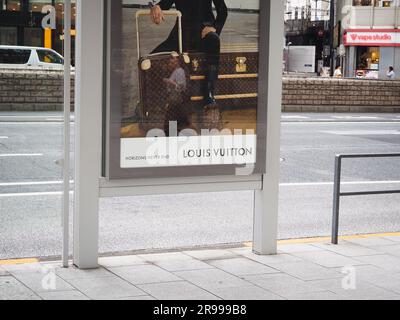 TOKIO, JAPAN - 13. Juni 2023: Details einer Louis Vuitton-Werbung, in der Gepäck und ein Fußball in einer Bushaltestelle in Tokios Ginza-Gegend gezeigt werden. Stockfoto