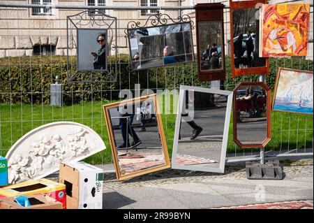 10.04.2023, Berlin, Deutschland, Europa - Menschen spiegeln sich in Spiegeln auf einem Flohmarkt entlang der Junistraße 17 zwischen Tiergarten und Charlottenburg wider. Stockfoto