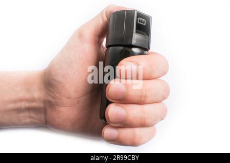 Hand mit einer Flasche Pfefferspray in die Augen, isoliert auf weißem Hintergrund Stockfoto