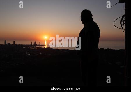 Batumi, Georgia. 24. Juni 2023. Ein Mann steht auf seinem Balkon bei Sonnenuntergang vor dem Hintergrund der Hafenstadt am Schwarzen Meer. Kredit: Sebastian Kahnert/dpa/Alamy Live News Stockfoto