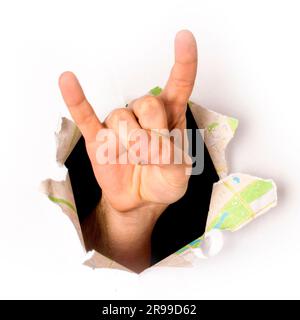 Nahaufnahme einer Hand, die aus einem Loch in weißem Papier kommt, ein Stein-und-Rollen-Schild, isoliert Stockfoto