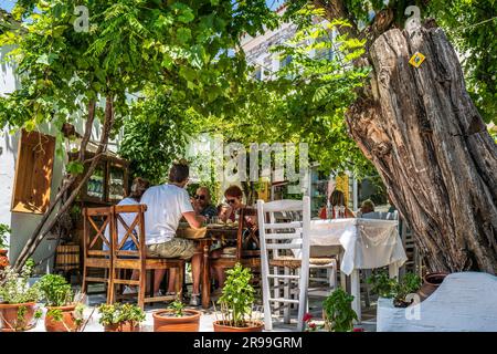 Traditioneller Dorftaverna-Innenhof in Halki, einem Bergdorf auf Naxos, Griechenland. Griechisches Essen. Stockfoto