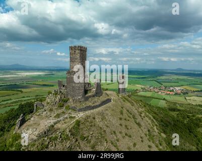 Die Überreste der mittelalterlichen Burg Hazmburk aus der Vogelperspektive mit einem runden und rechteckigen Turm befinden sich auf dem Gipfel dieses Niedriggipfels mit Landschaft Stockfoto