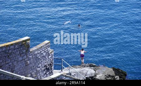 Plymouth, Devon, England - 6 2022. Juli: Besucher, die Freizeit im Plymouth Sound verbringen, baden im kühlen blauen Meer und spazieren entlang der Hafenmauer Stockfoto