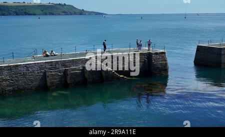 Plymouth, Devon, England - 6 2022. Juli: Besucher, die Freizeit im Plymouth Sound verbringen, baden im kühlen blauen Meer und spazieren entlang der Hafenmauer Stockfoto