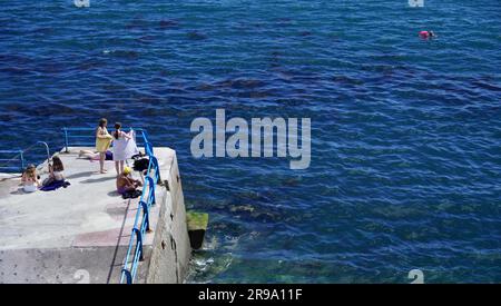 Plymouth, Devon, England - 6 2022. Juli: Besucher, die Freizeit im Plymouth Sound verbringen, baden im kühlen blauen Meer und spazieren entlang der Hafenmauer Stockfoto